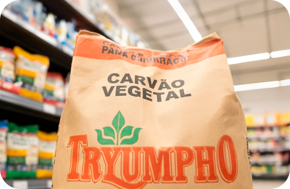 Saco de carvão vegetal Tryumpho em um corredor de supermercado.