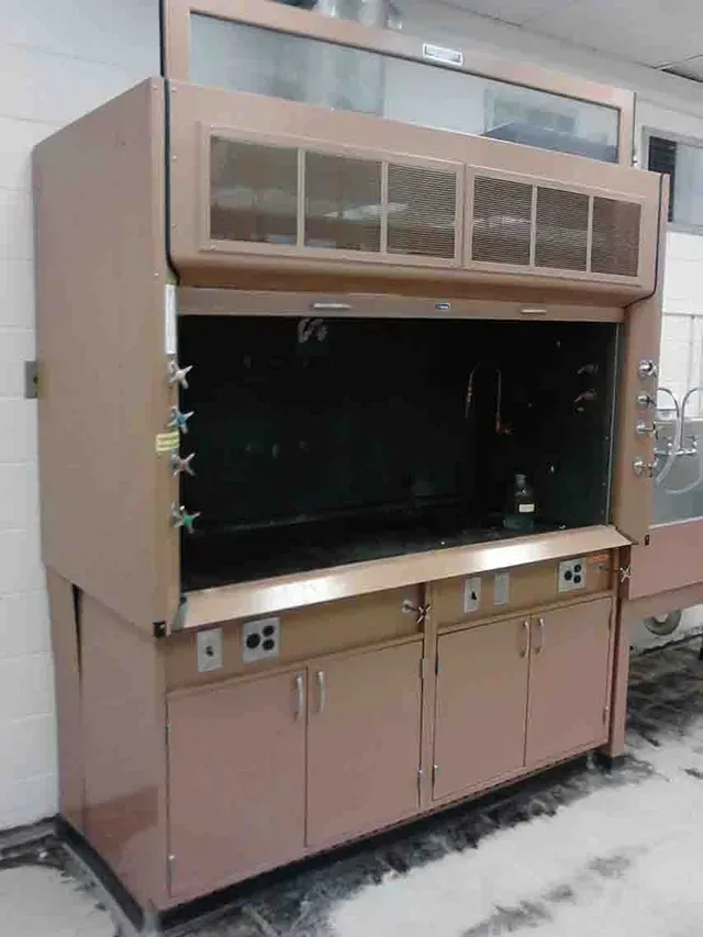 Pink fume hood in a lab setting with cabinet storage below.