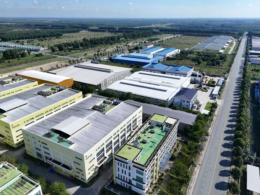Aerial view of industrial buildings and a road in an expansive outdoor setting.