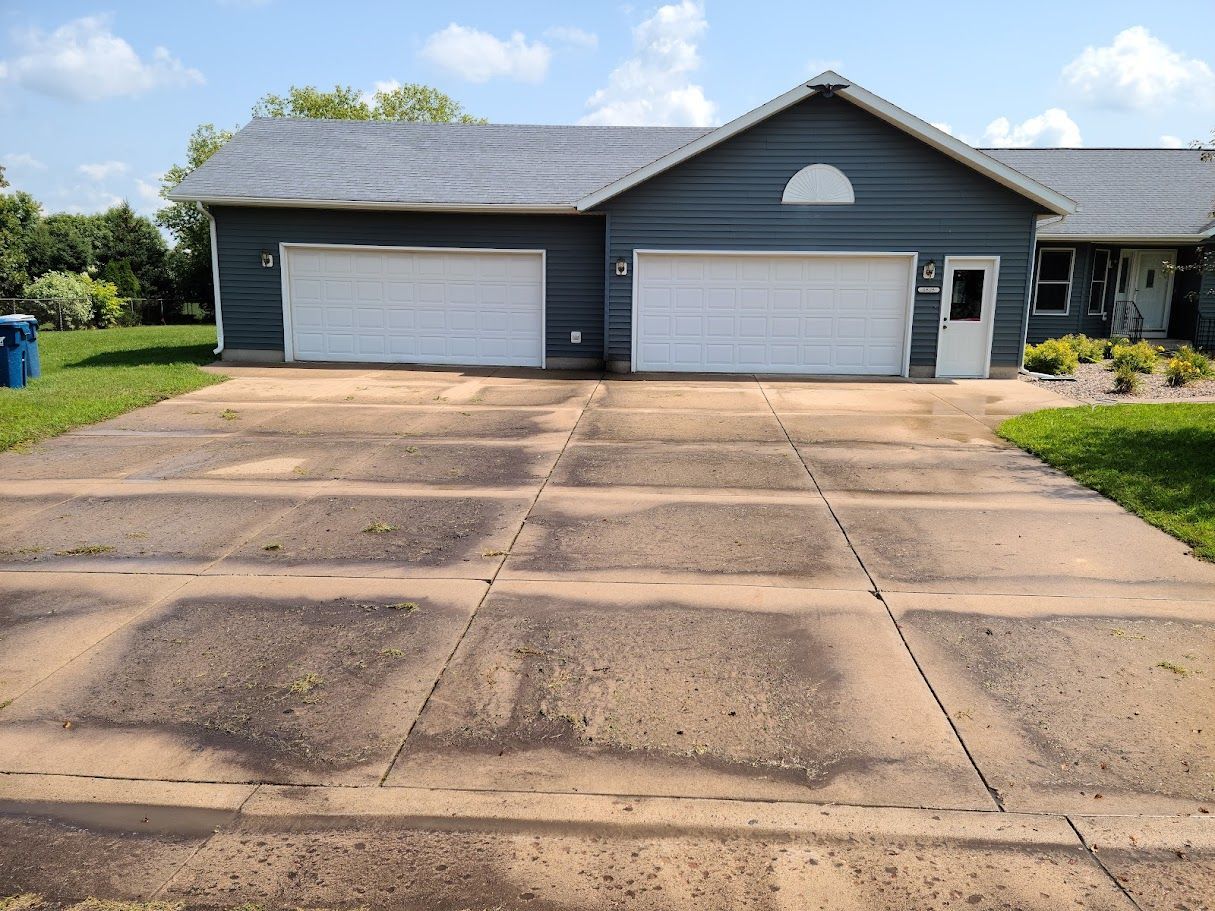 A house with two garage doors and a concrete driveway