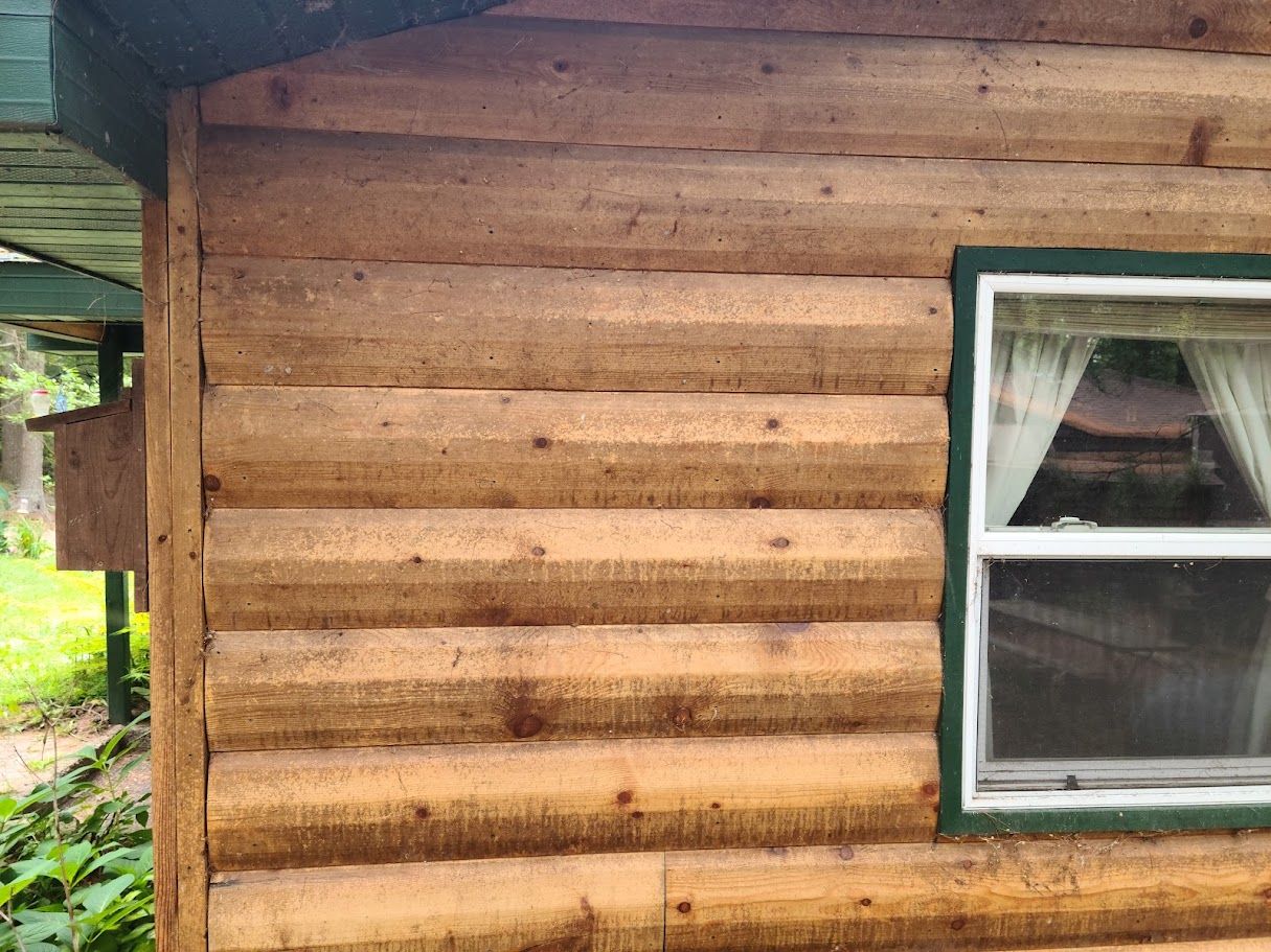 A log cabin with a window on the side of it.