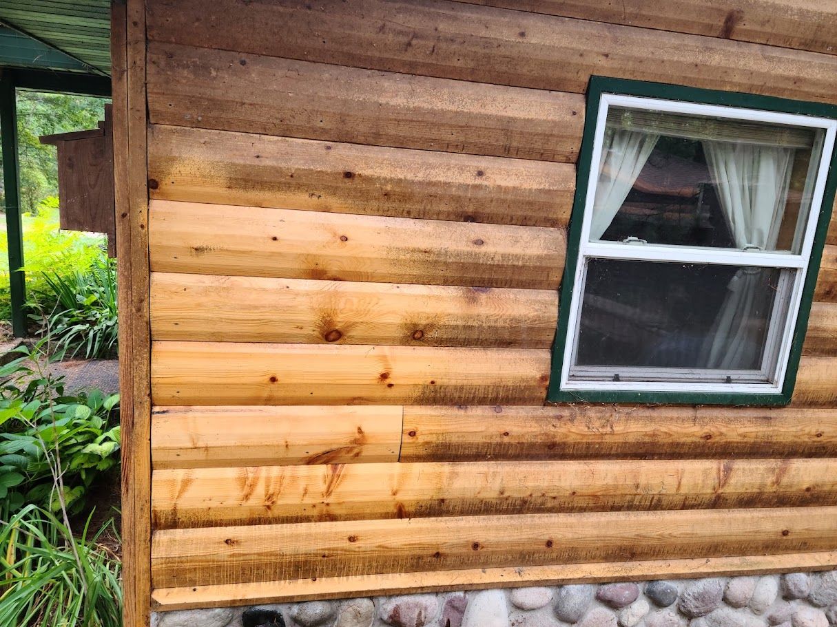 A log cabin with a window on the side of it.
