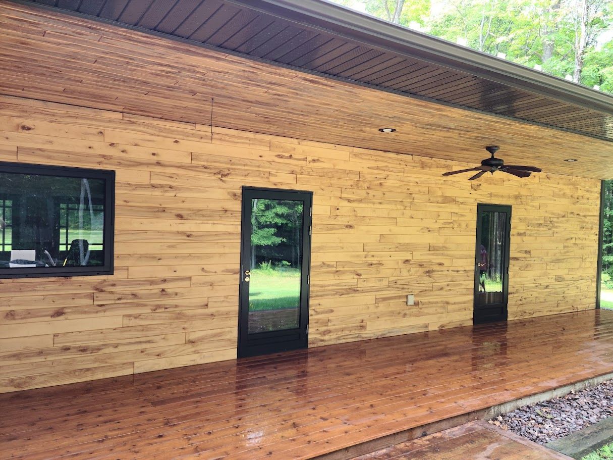 A large wooden house with a patio and a ceiling fan.