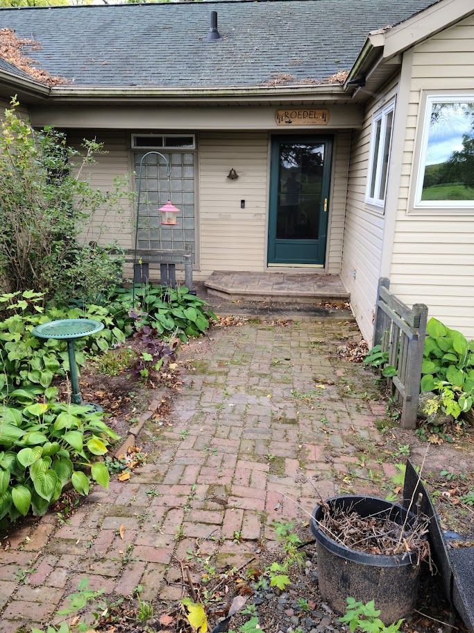 A brick walkway leading to the front door of a house.