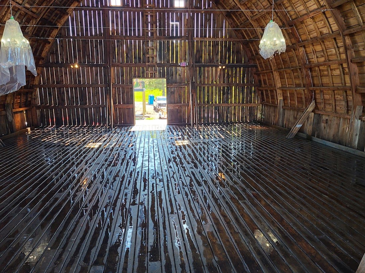 The inside of a barn with a lot of knives on the floor.