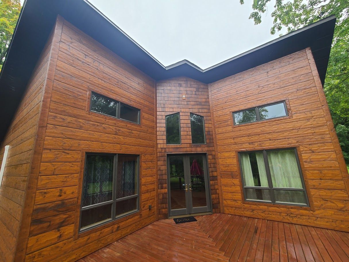 A large wooden house with a large deck in front of it.