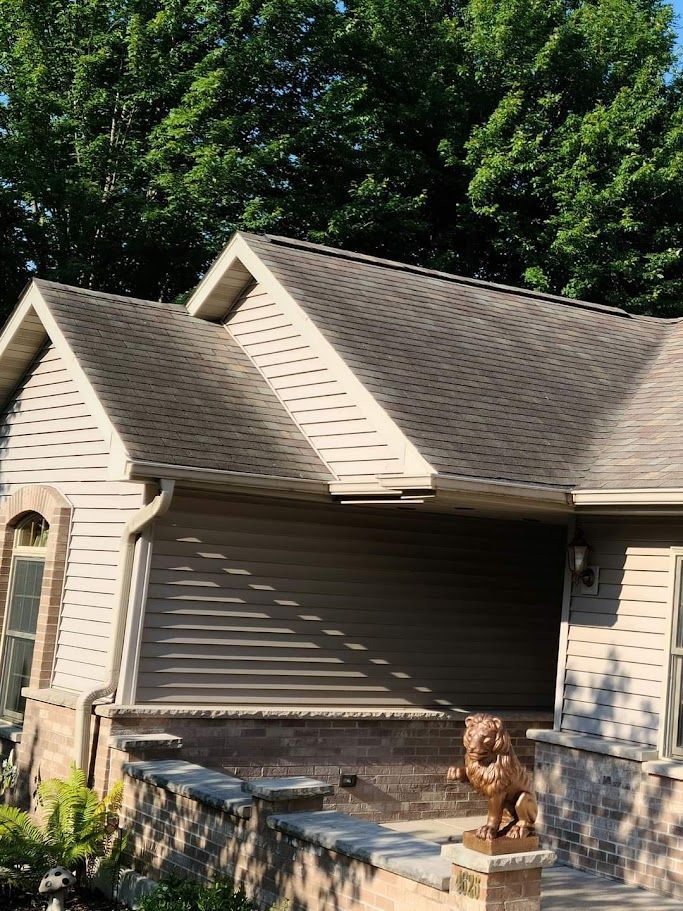 A statue of a dog is on the porch of a house.