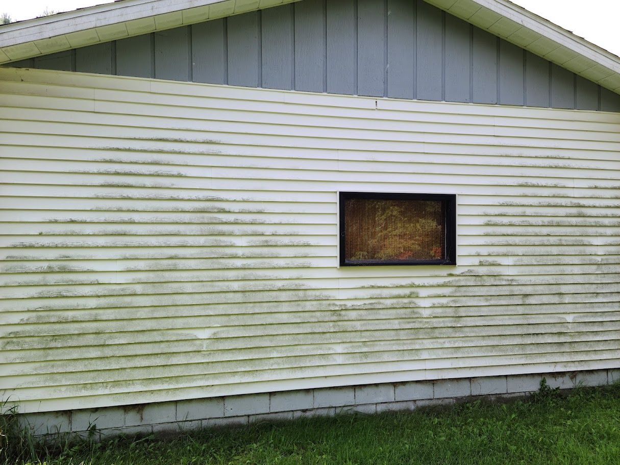 A white house with a window on the side of it.