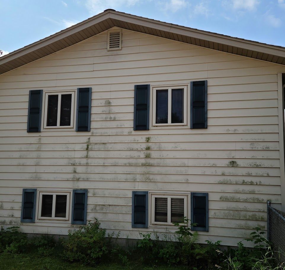 A white house with blue shutters and a sign that says ' waiting '