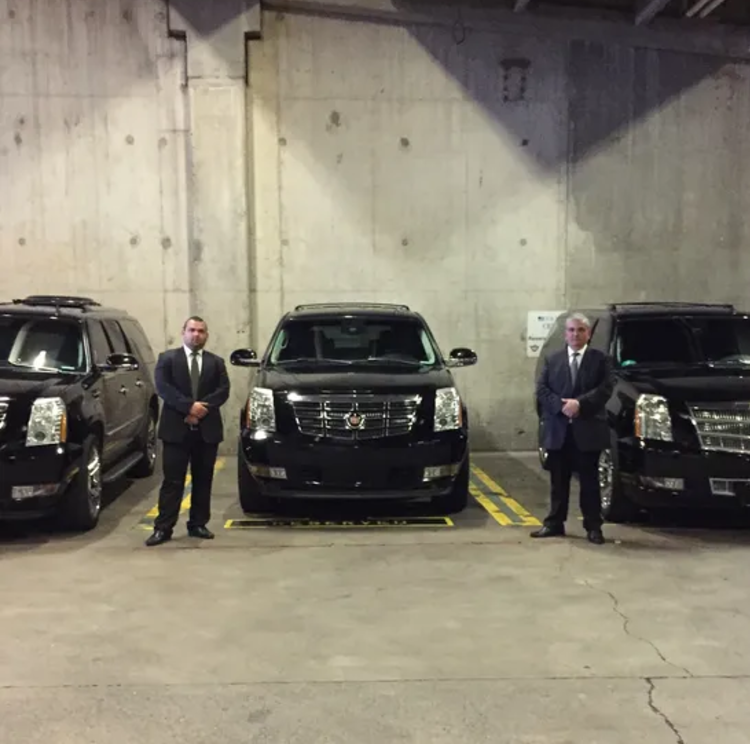 A man in a suit and tie is sitting in the back seat of a car