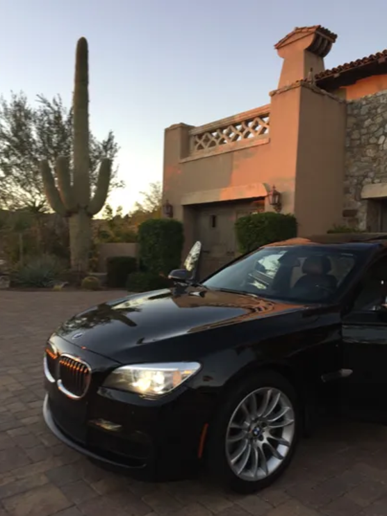 A man in a suit and tie is sitting in the back seat of a car
