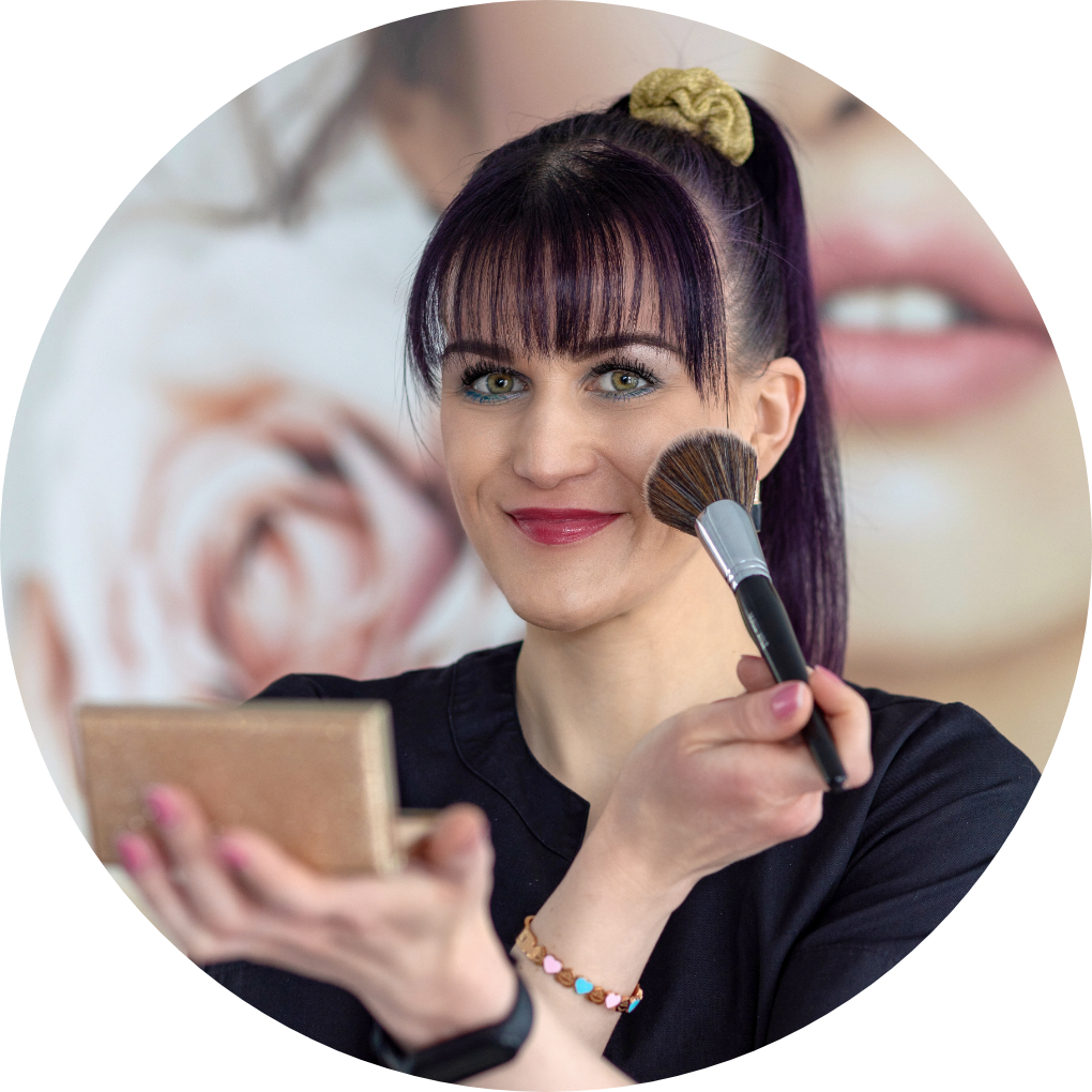 Eine Frau mit lila Haaren trägt Make-up mit einem Pinsel auf