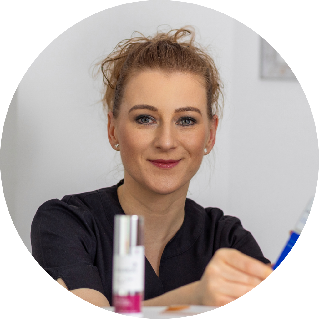 Eine Frau sitzt an einem Tisch mit einer Flasche Lotion vor sich