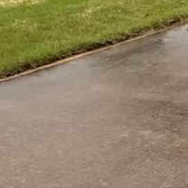 A driveway being cleaned by high pressure washer.