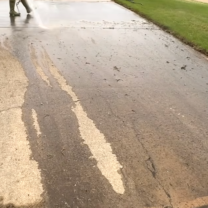 A person is cleaning a dirty sidewalk with pressure washer.
