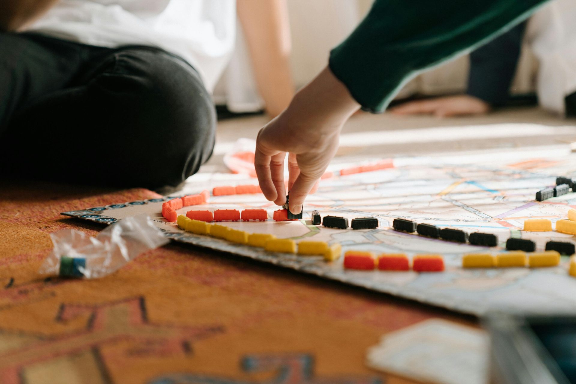 Family playing board games around spacious lodge kitchen table during holiday