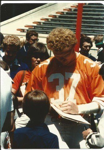 A man in an orange jersey with the number 27 on it