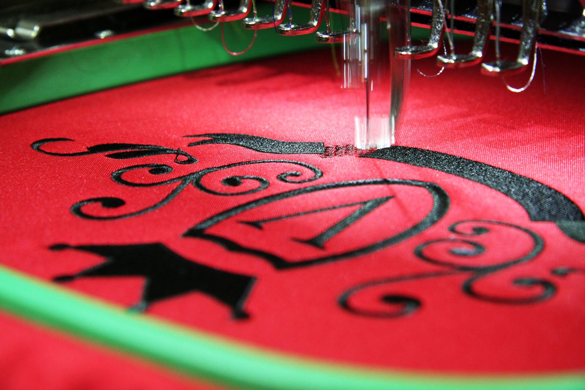 Eine Nahaufnahme einer Nähmaschinenstickerei auf einem roten Stoff