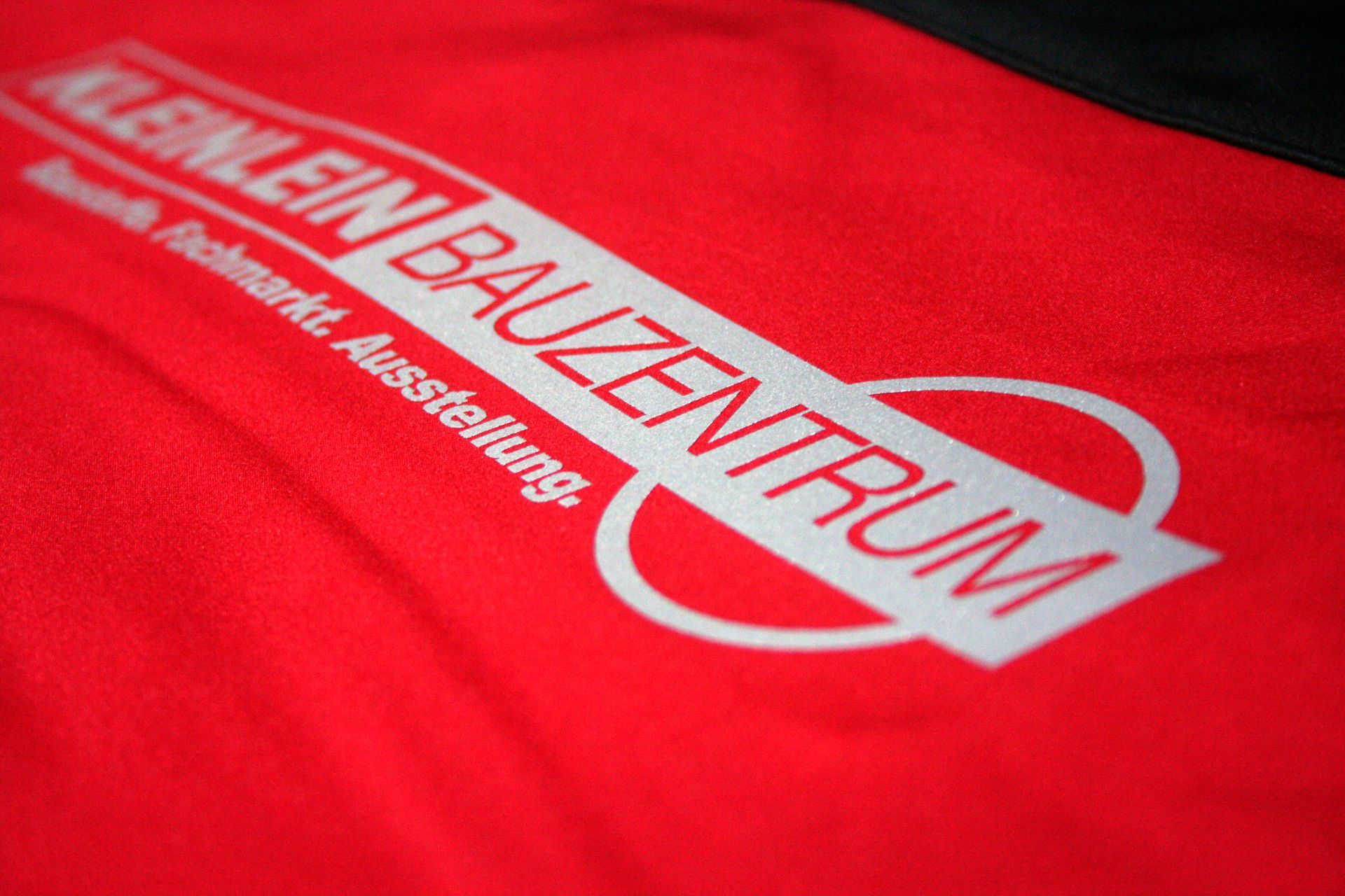 Eine Nahaufnahme eines roten Shirts mit der Aufschrift „Kleinlein Bauzentrum“