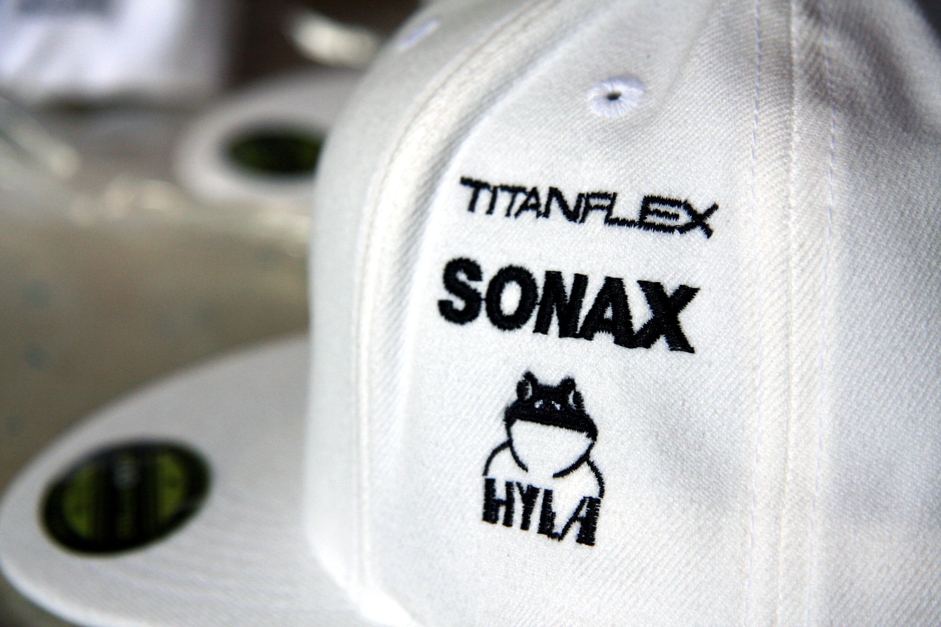 Eine weißer Snapback mit der Aufschrift „Sonax“