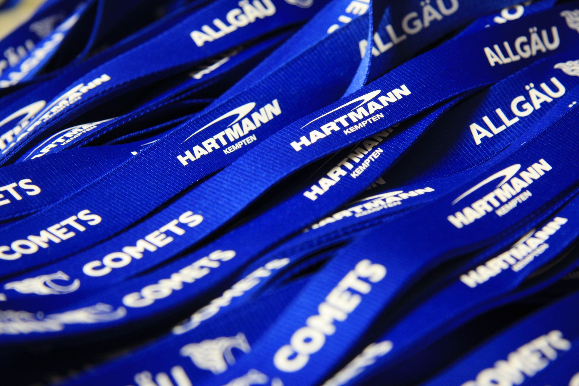 Ein Bündel blauer Schlüsselbänder mit der Aufschrift „COMETS. ALLGÄU und Hartmann“
