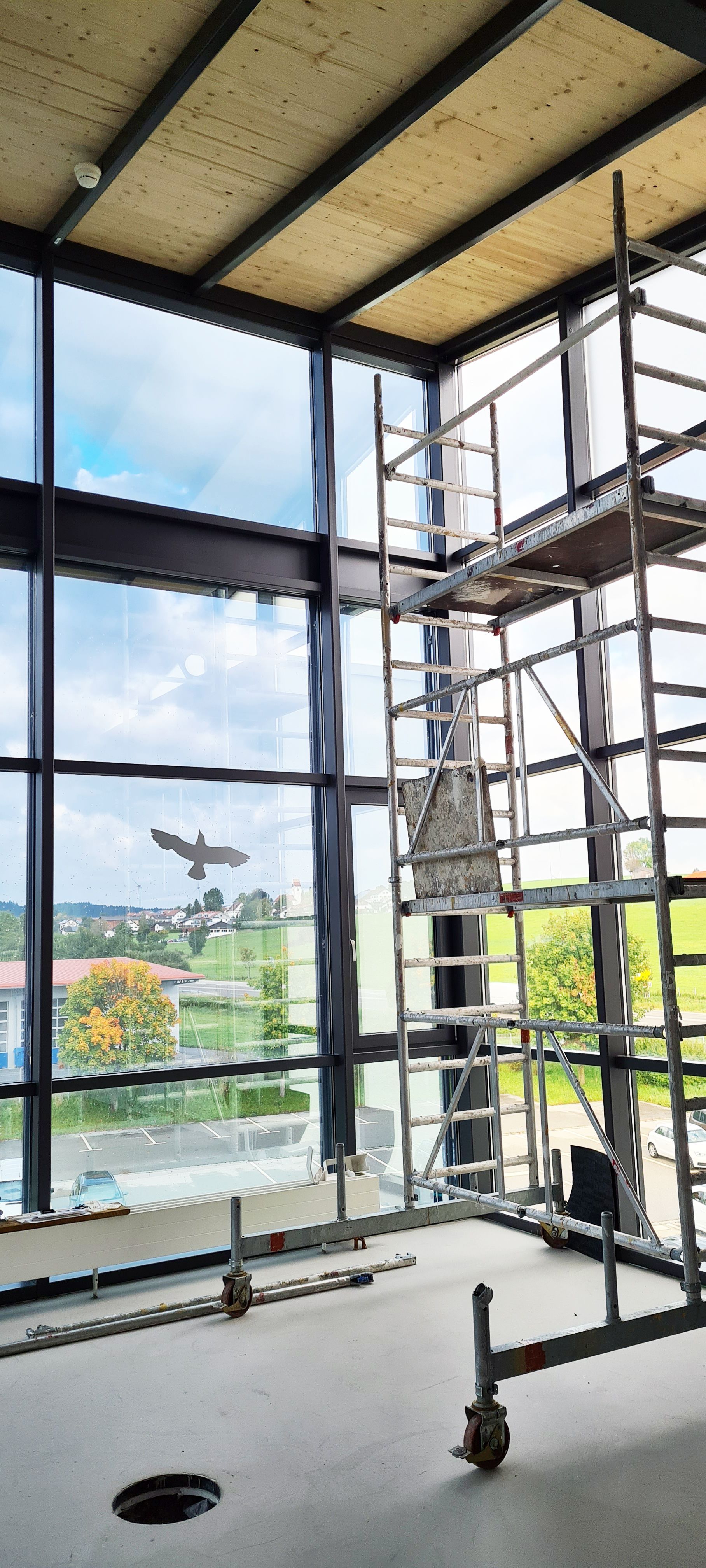 Ein Gebäude mit Gerüst und einem großen Fenster.