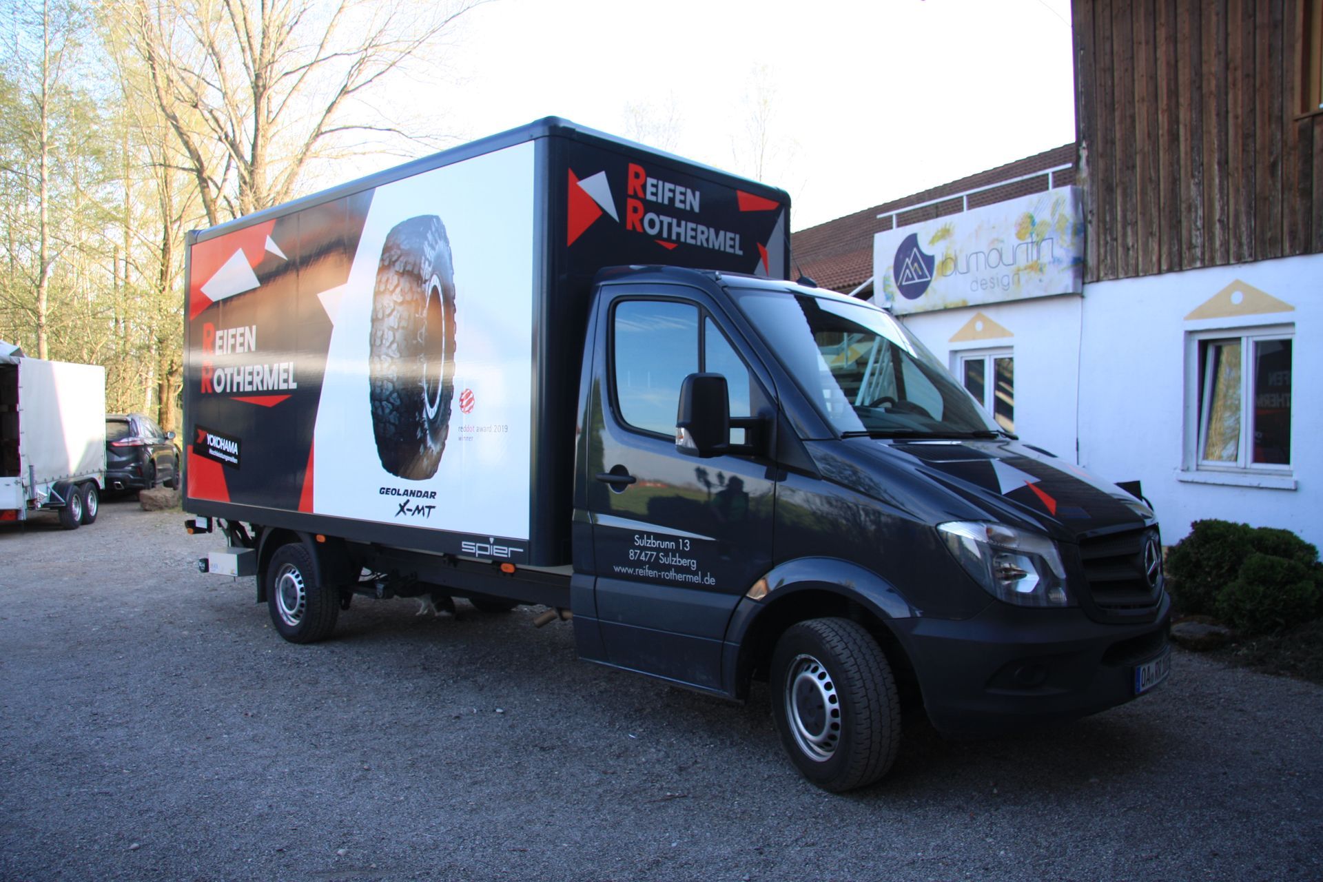 Ein schwarzer beklebter Lieferwagen steht vor einem Gebäude