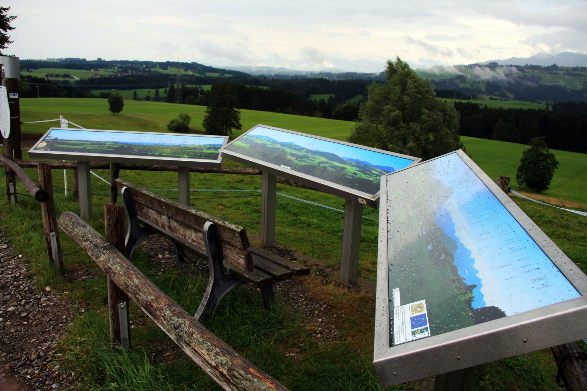 Eine Holzbank steht neben einem Schild mit der Aufschrift 