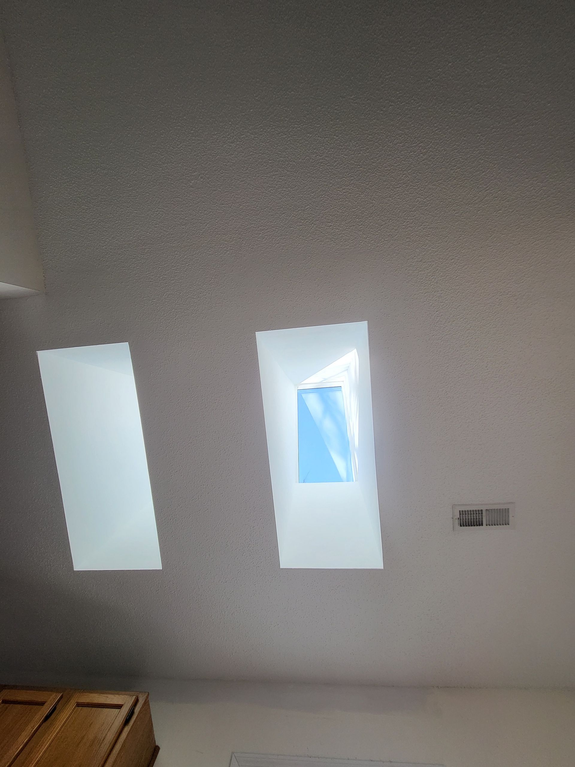 There are two skylights in the ceiling of a room.