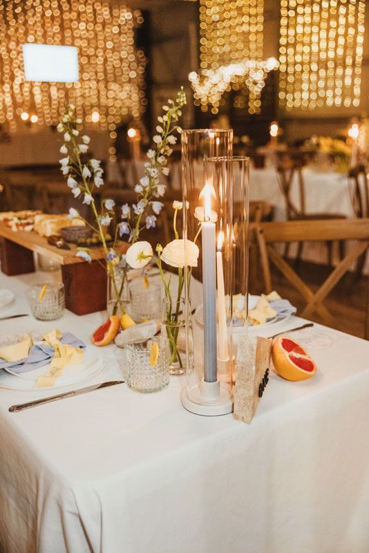 A table with a vase of flowers and candles on it.