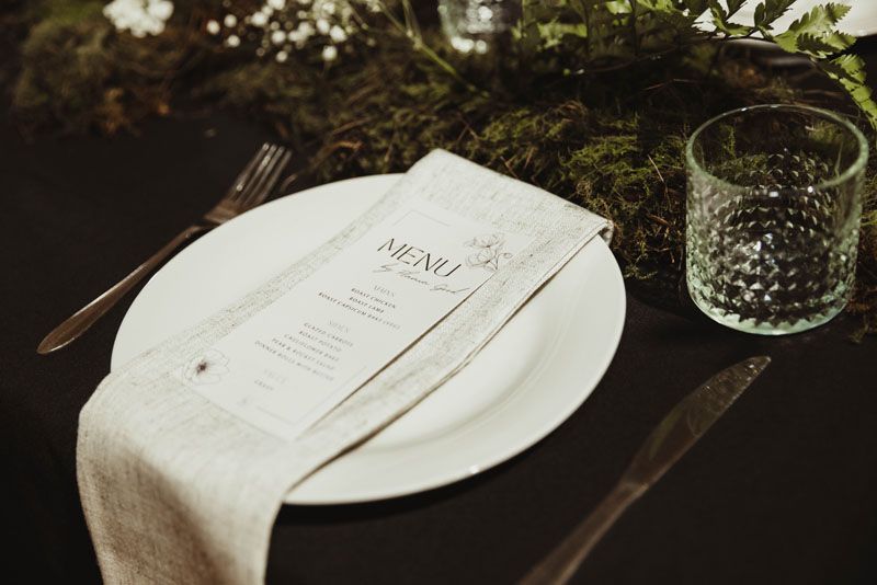 A white plate with a menu on it is on a table.