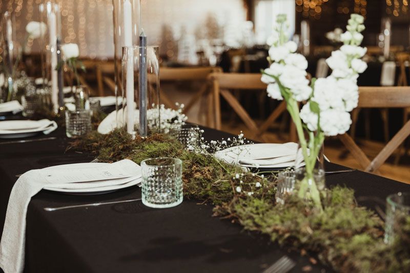 A table with plates , glasses , candles and flowers on it.