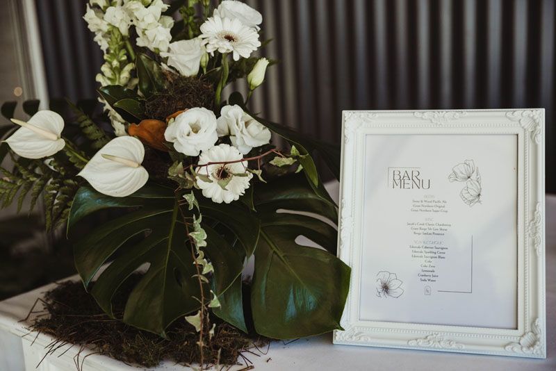 A table with flowers and a picture frame on it.