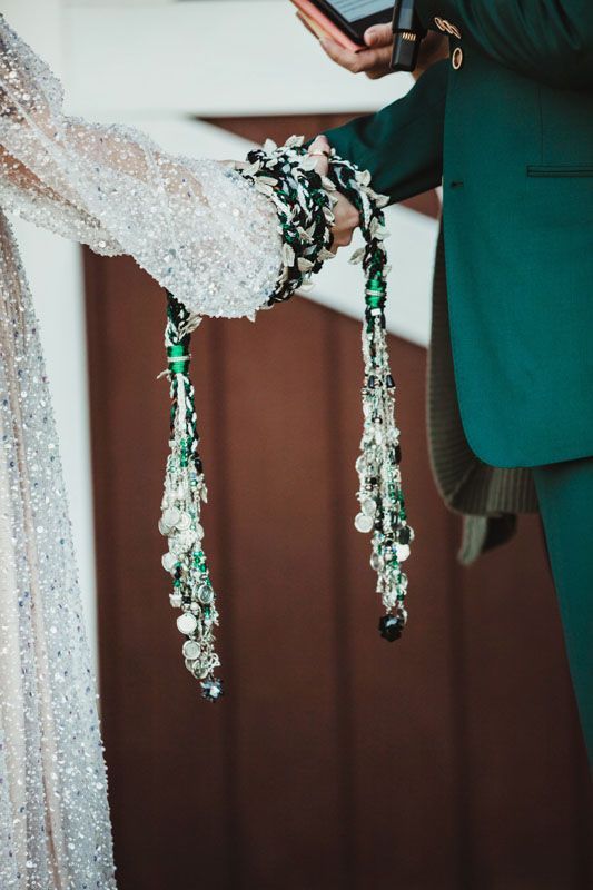 A bride and groom are holding hands during a wedding ceremony.