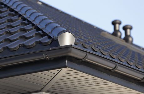 A close up of a gutter on a roof of a house.