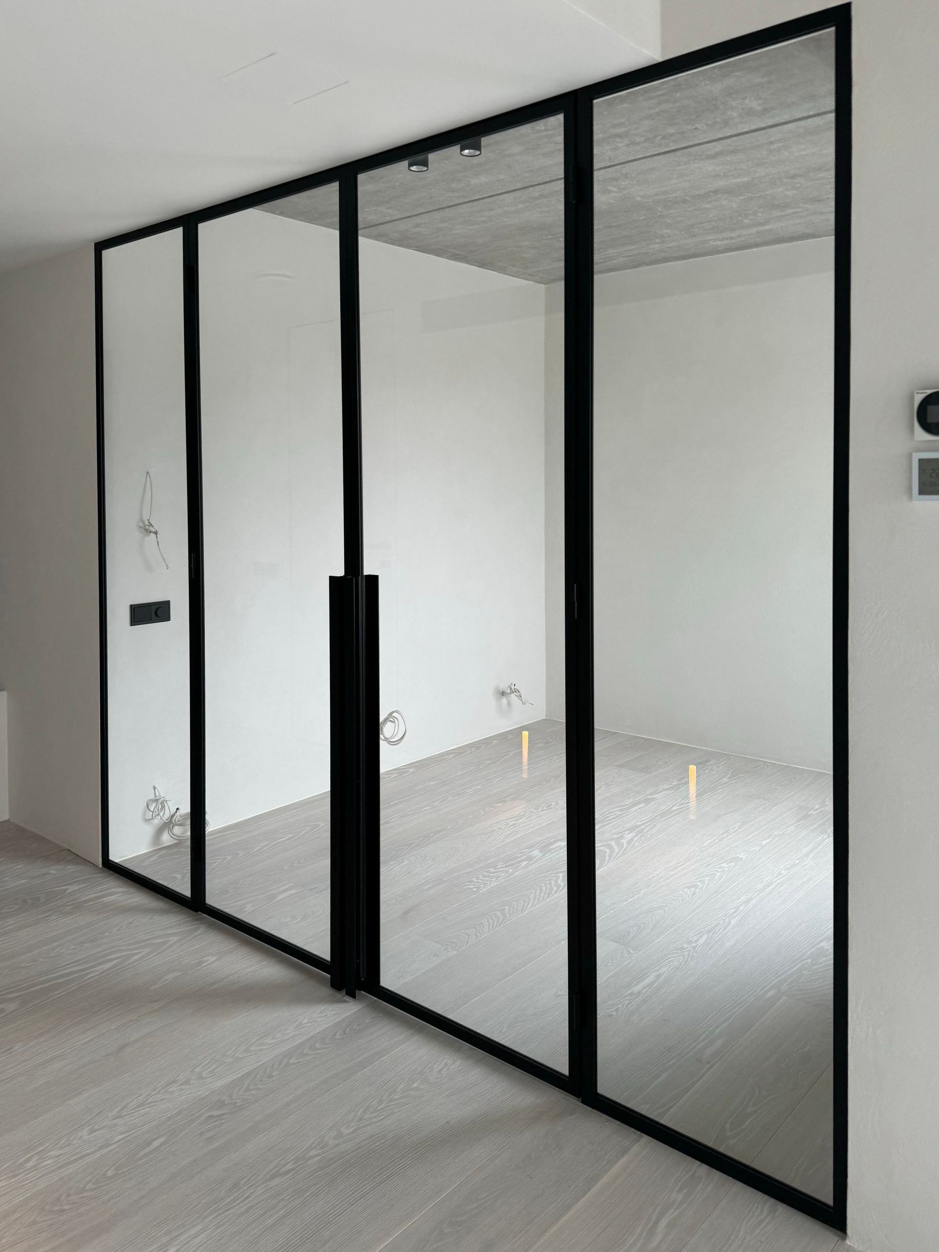 Klaassein paarisustega mustas raamis, kirgas klaas.  klaasseinad, klaassein, klaasvaheseinad, klaasist vaheseinad. Klaasseinad, klaasist sein. Klaassein klaasuks