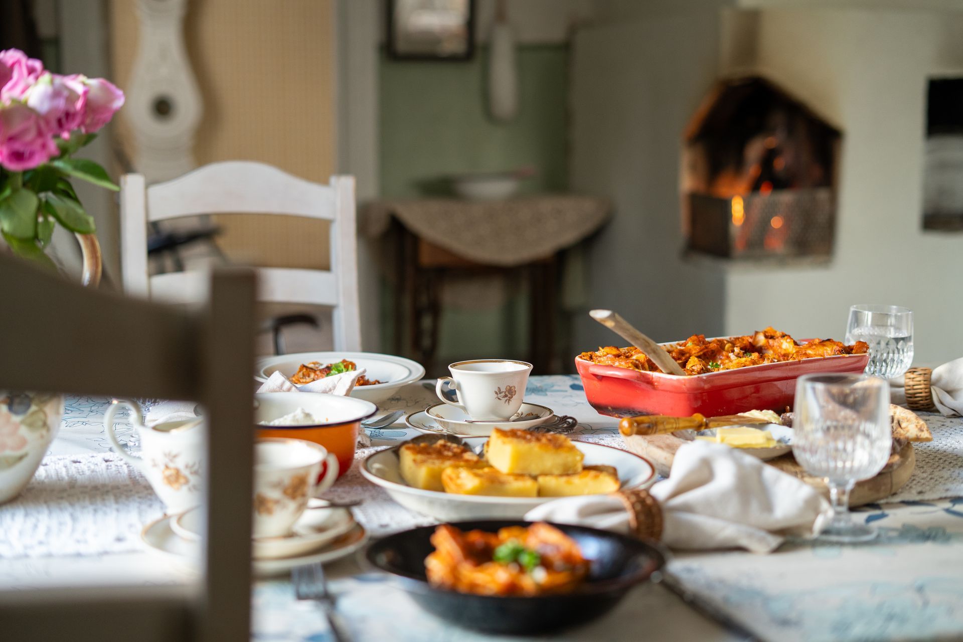 Table set in a rustic house setting with fire in the background