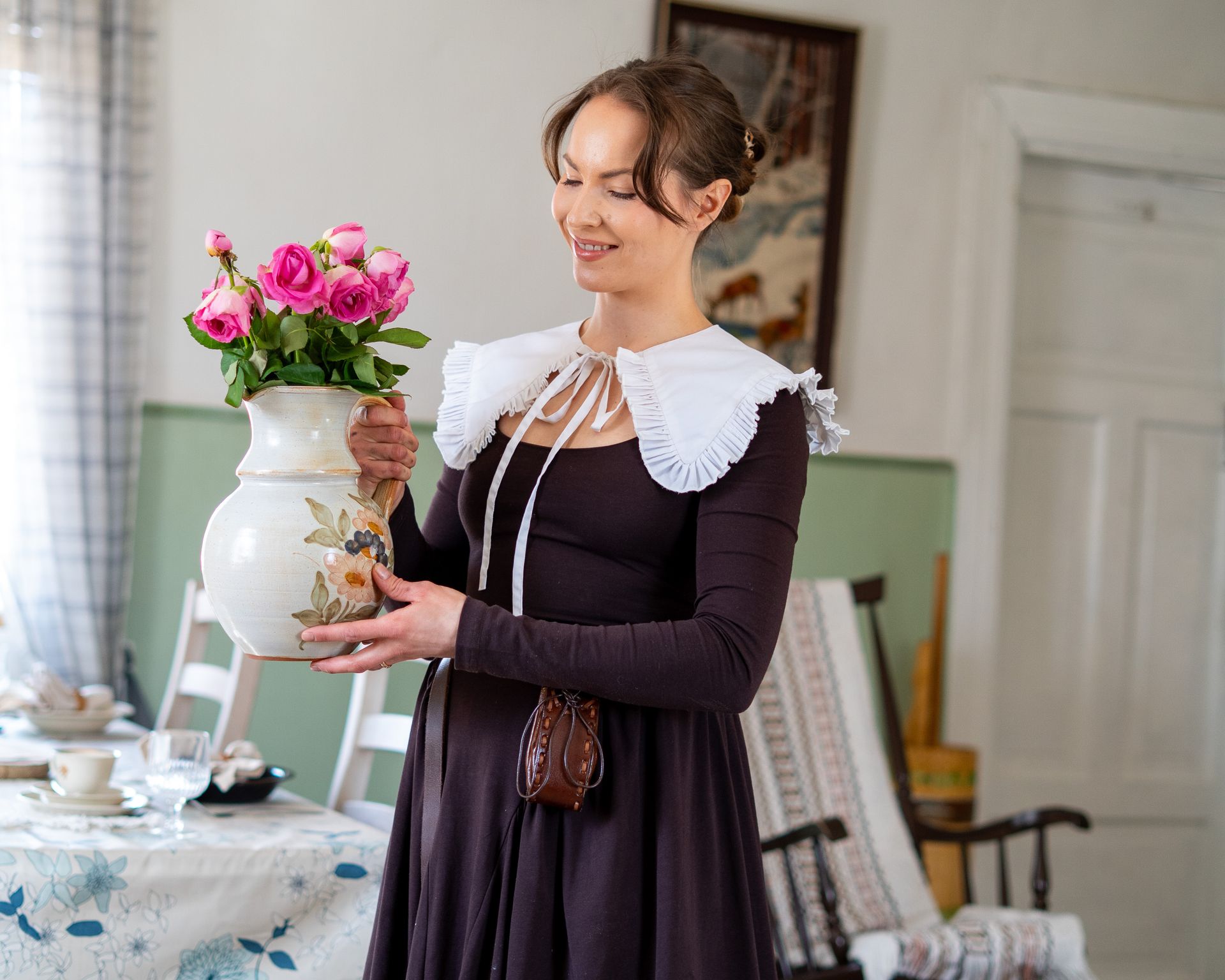 Woman in a vintage dress with flowers in an old house setting