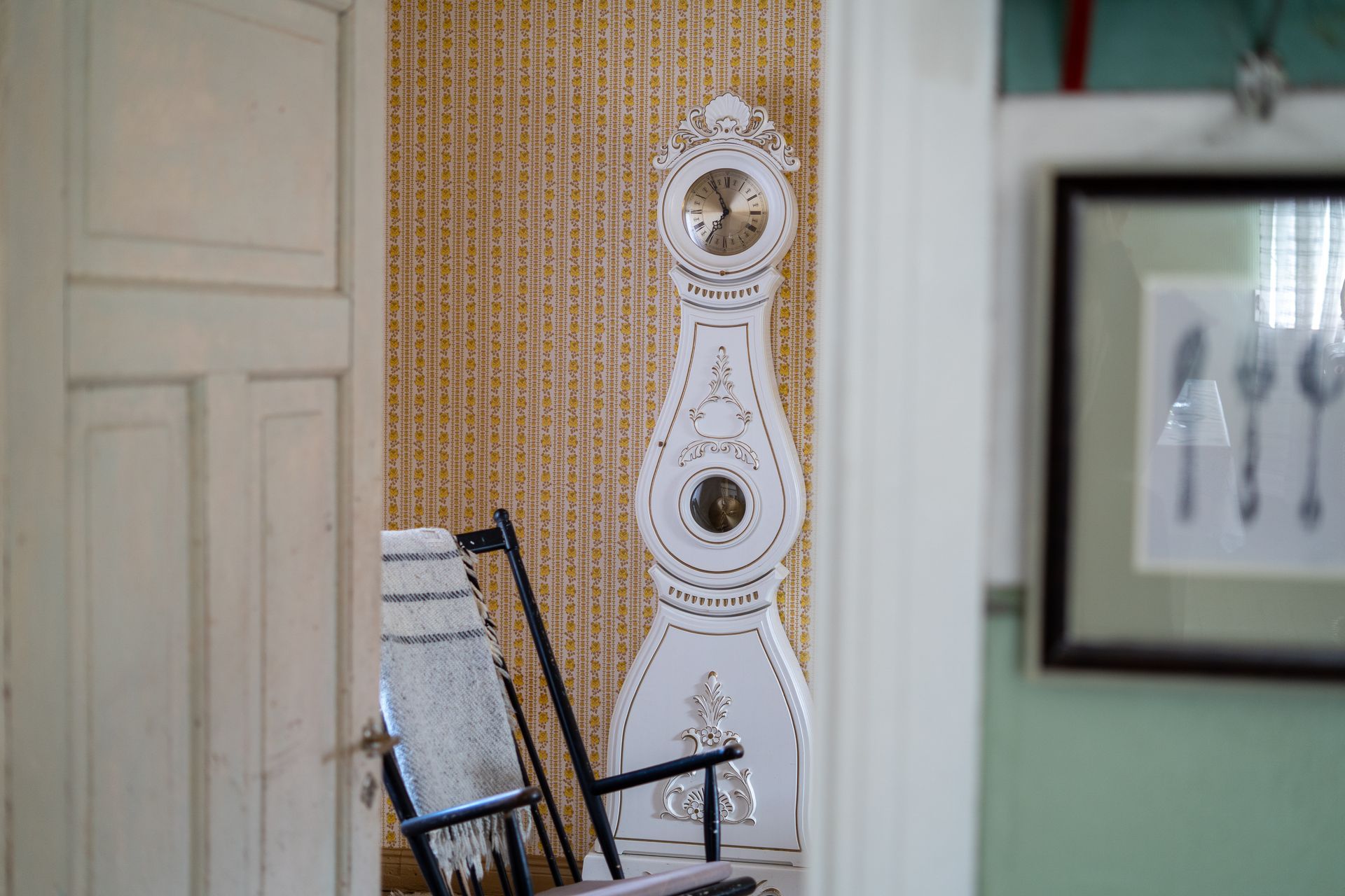 Old wooden house clock and a rocking chair in an old house