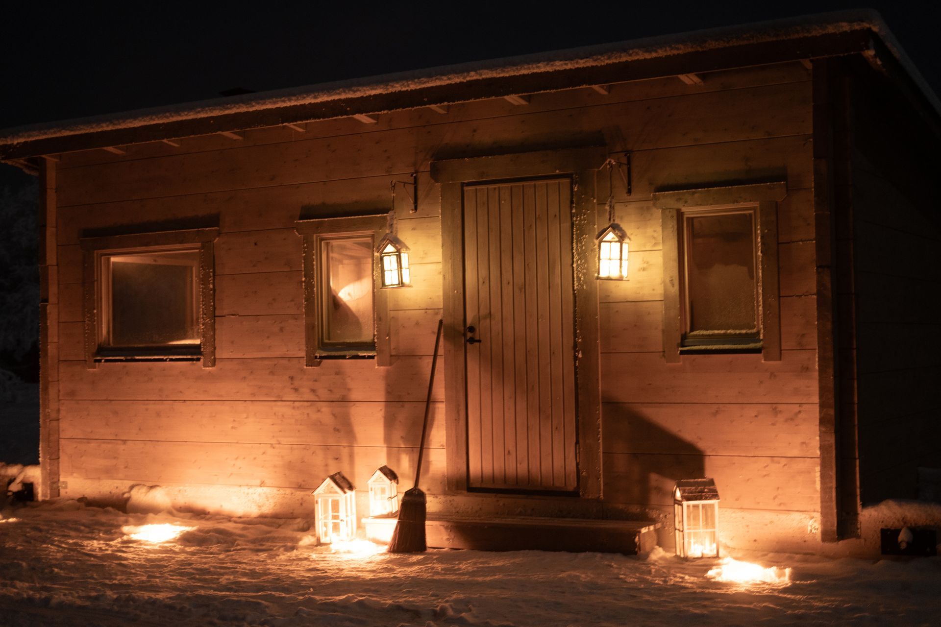 Candle lit outdoor view of log cabin.