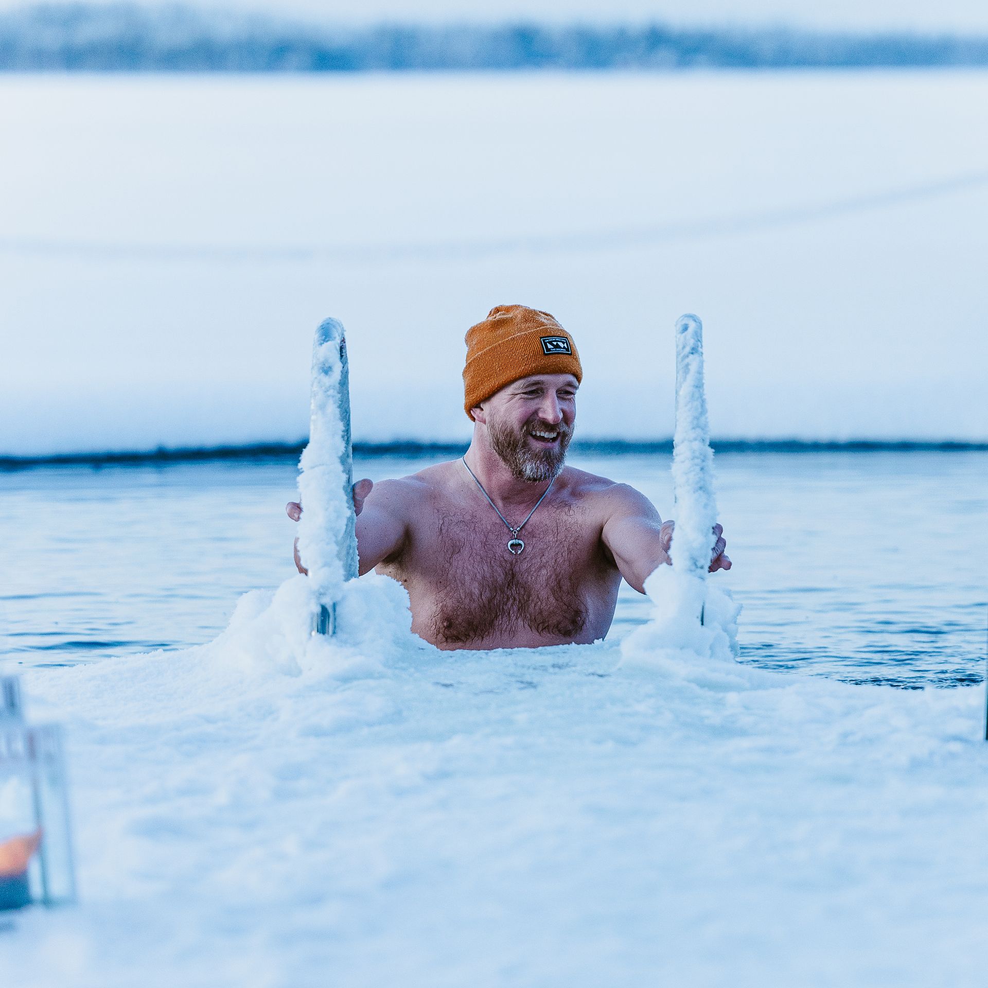 Man getting in an ice hole to do ice swimming.