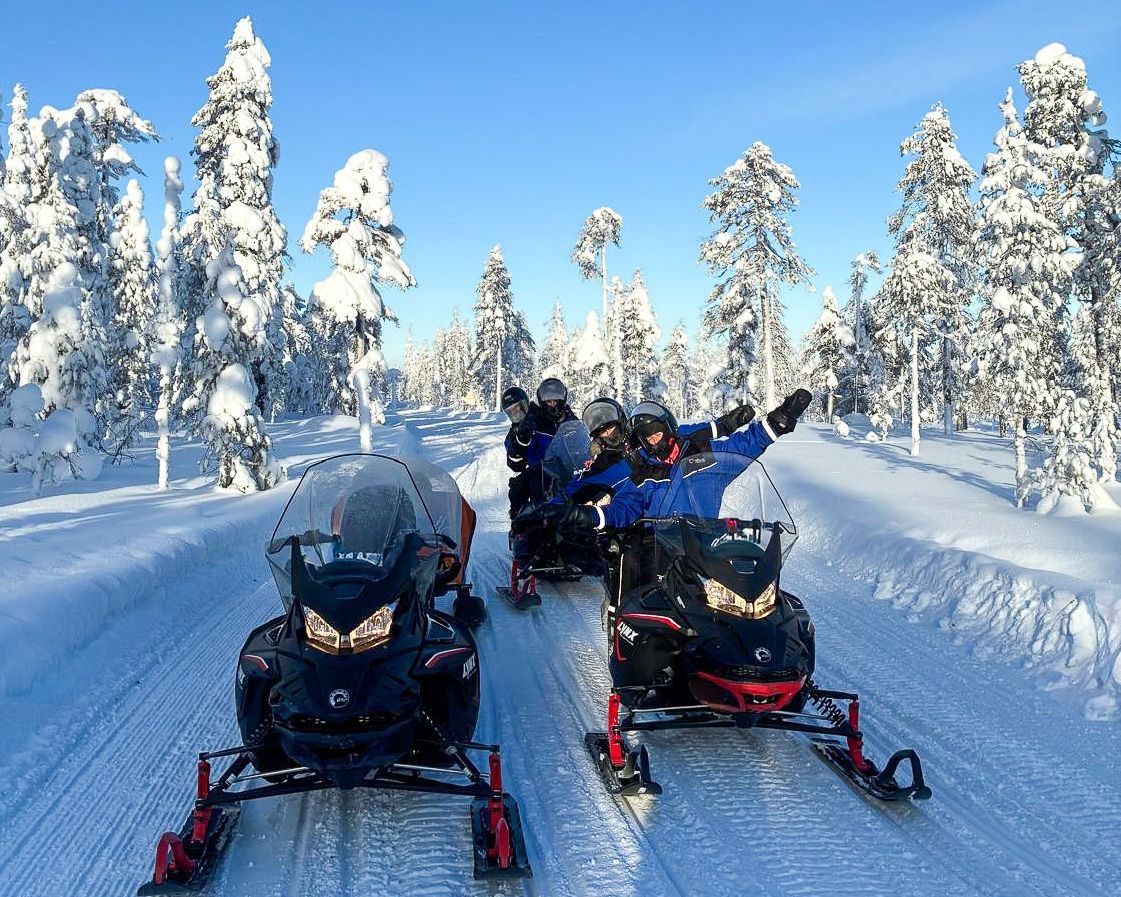 Snowmobiling people in snowy landscape.