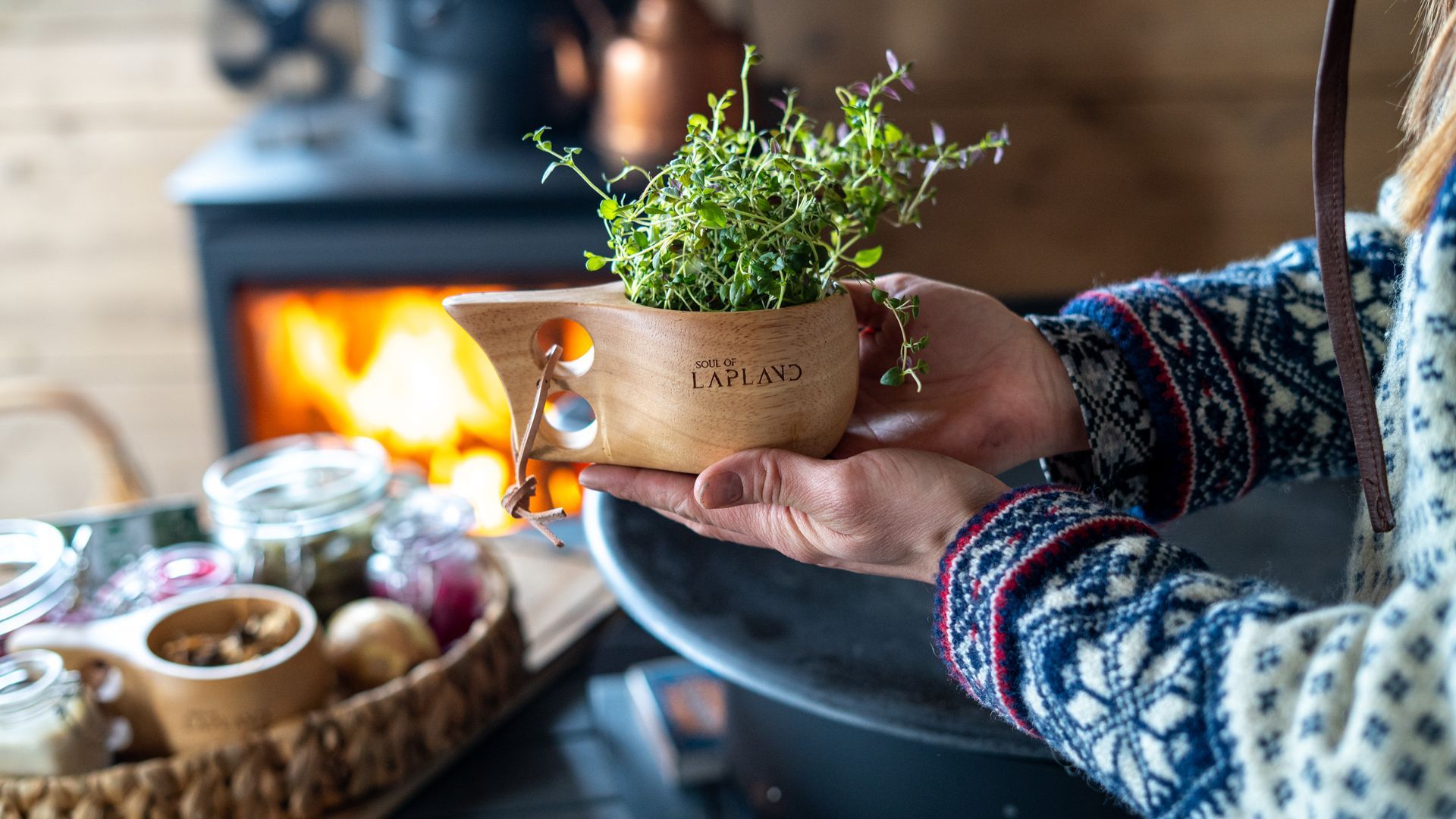 Herbs in a kuksa with fire in the back ground