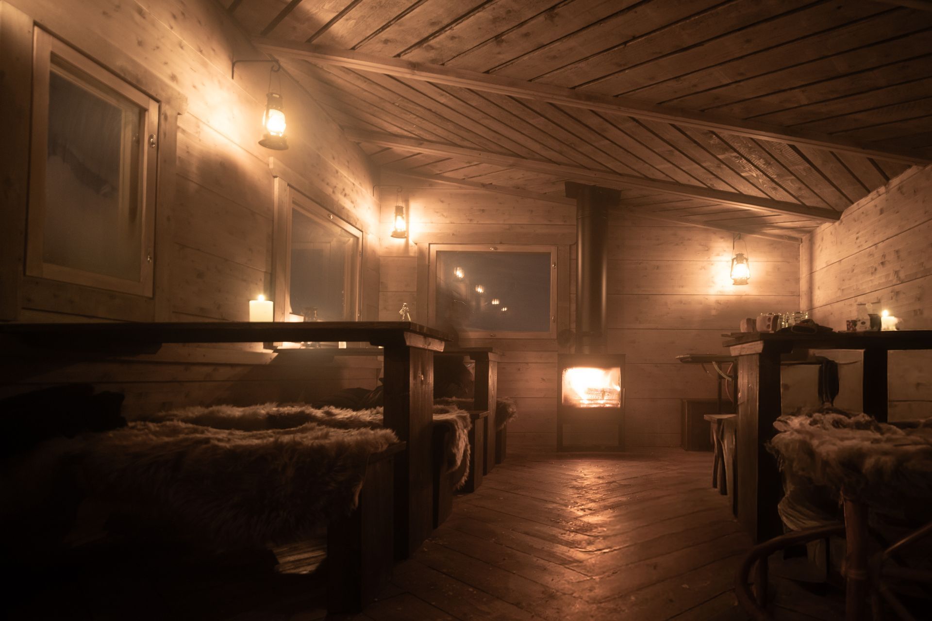 Candle lit log cabin interior with fire place.