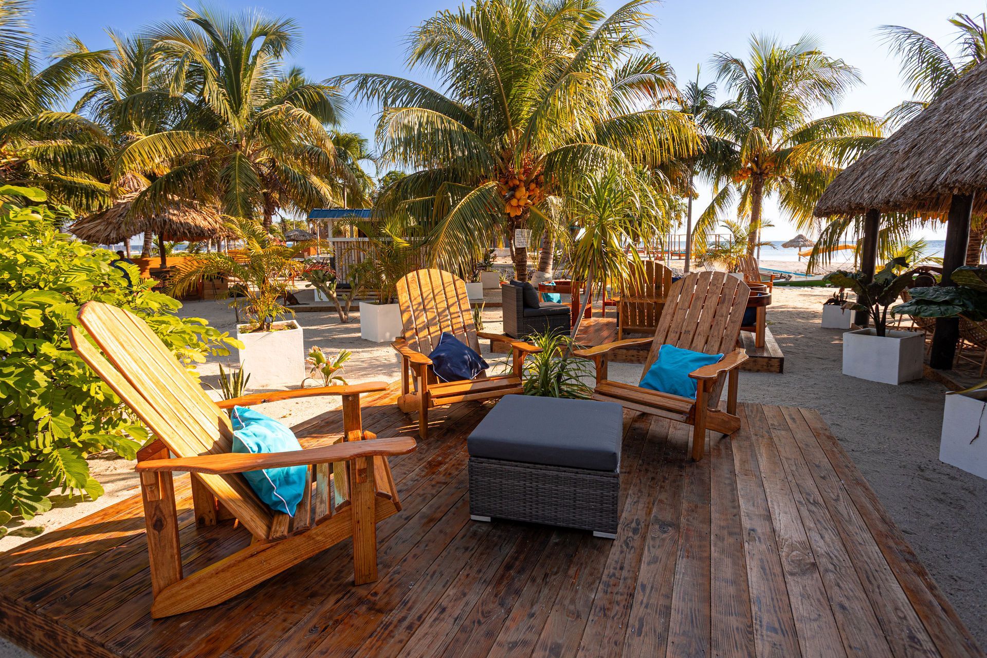 Beachfront hut with thatched roof on a wooden platform; blue ocean, cloudy sky.