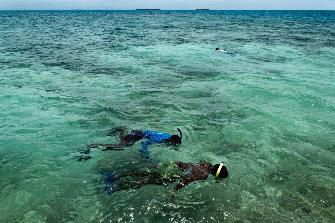 Two people snorkeling in clear turquoise water.