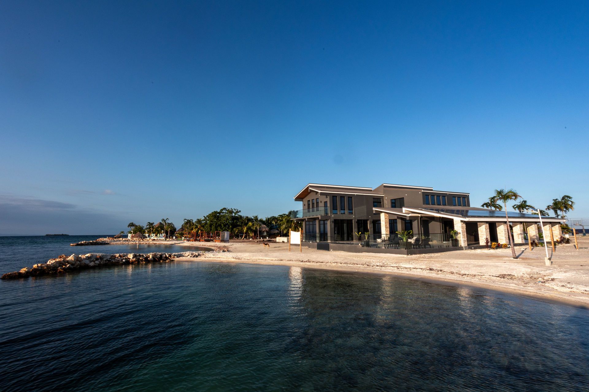 Ocean view with trees and a bright blue sky.