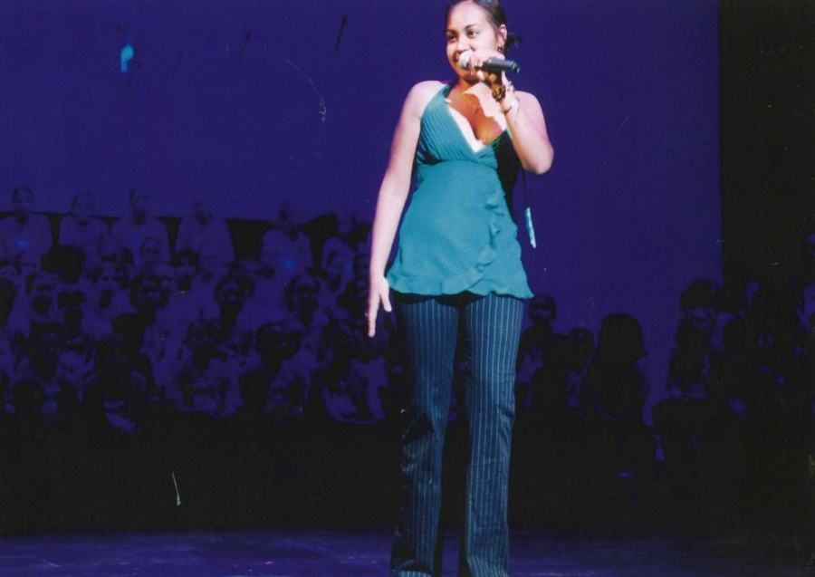 A woman singing into a microphone on a stage