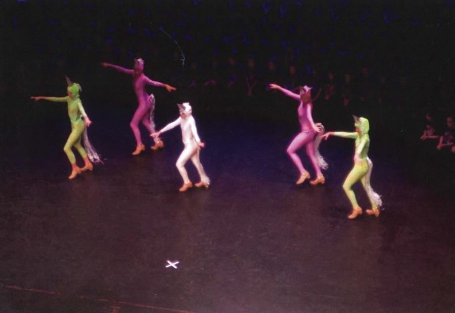 A group of people in colorful costumes are dancing on a stage