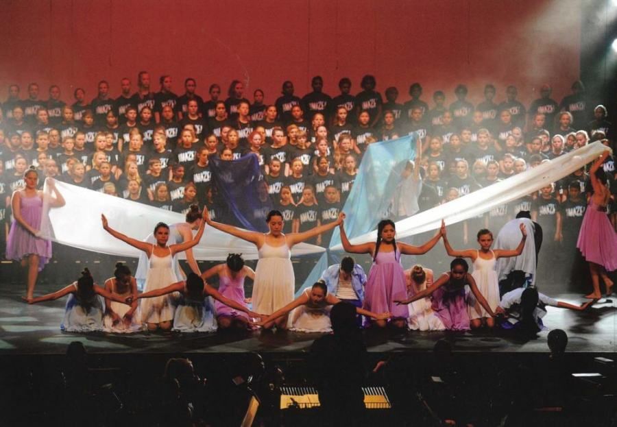 A large group of people are dancing on a stage